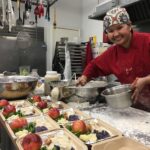 Chef in kitchen at South Park Senior Center preparing meals for delivery to older adults