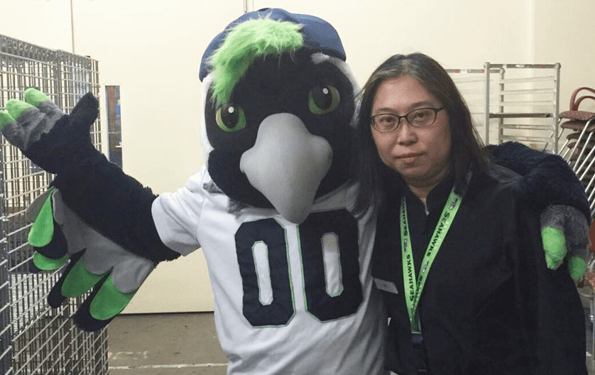 Sze poses with her arm around Seattle Seahawks mascot Boom.