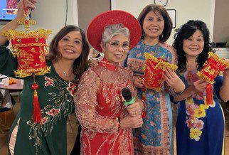 Four older, Asian/Pacific Islander women wearing traditional clothing and holding lanterns in celebration of Lunar New Year.