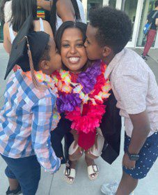 Eldad Mekuria at graduation, kissed by two young children