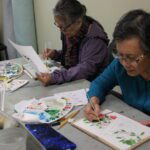 two of ACRS Club Bamboo clients painting in a class.