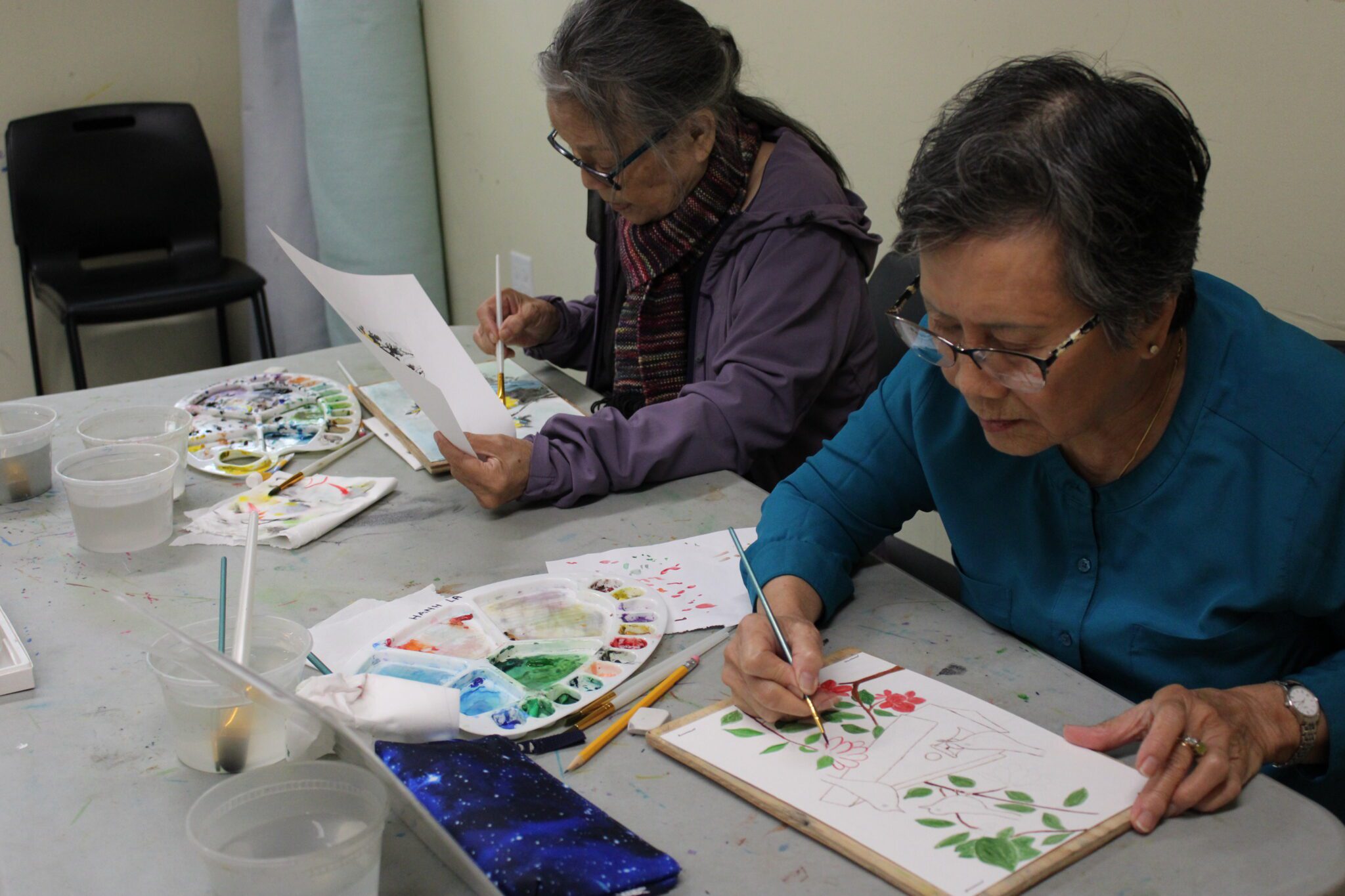 two of ACRS Club Bamboo clients painting in a class.