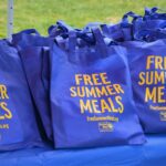 Photo of blue bags that say "Free Summer Meals"