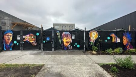 Gated entrance to a transitional housing village featuring brightly painted pictures