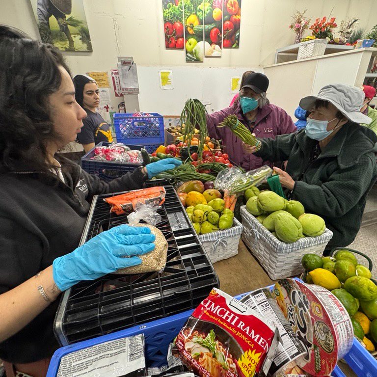 Photo of volunteers sorting food and assisting shoppers at the Asian Counseling and Referral Service food bank in November. (Photo courtesy ACRS.)