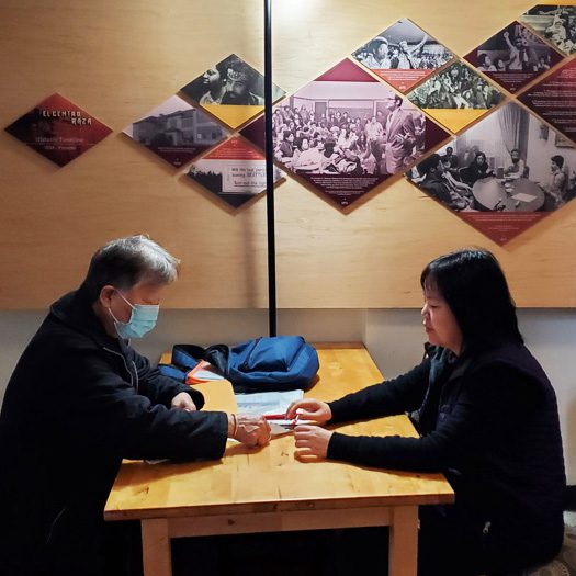 Katie Yuen meets with a client wearing a mask at El Centro de la Raza.